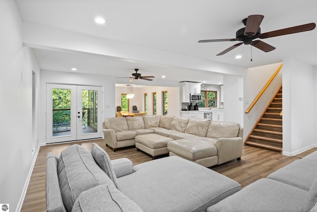 living room featuring light hardwood / wood-style flooring, ceiling fan, and french doors