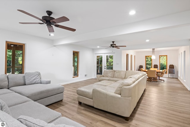 living room with light hardwood / wood-style floors, ceiling fan, and french doors