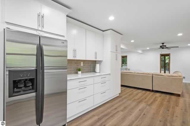 kitchen with ceiling fan, white cabinets, tasteful backsplash, light hardwood / wood-style flooring, and stainless steel refrigerator with ice dispenser