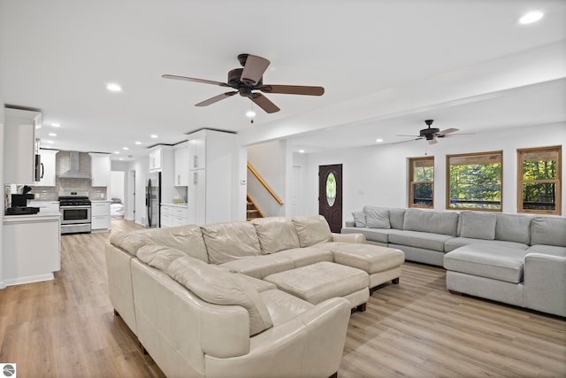 living room with ceiling fan and light wood-type flooring