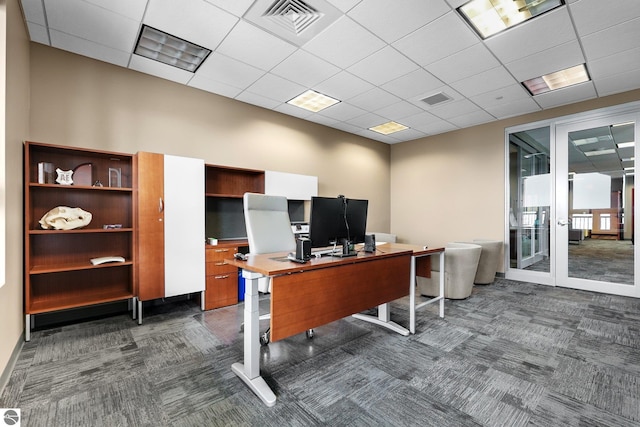 carpeted office space featuring a paneled ceiling