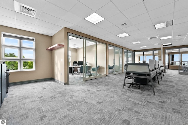 interior space featuring a paneled ceiling and carpet flooring