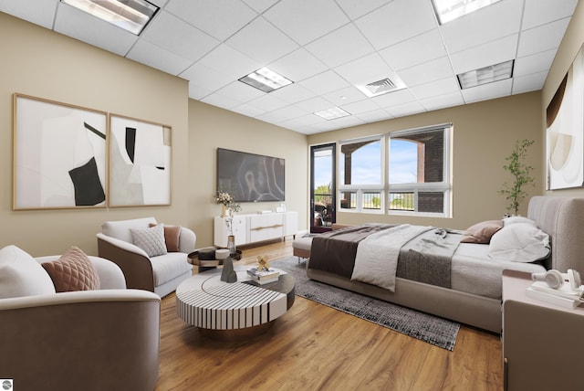 bedroom with wood-type flooring and a paneled ceiling