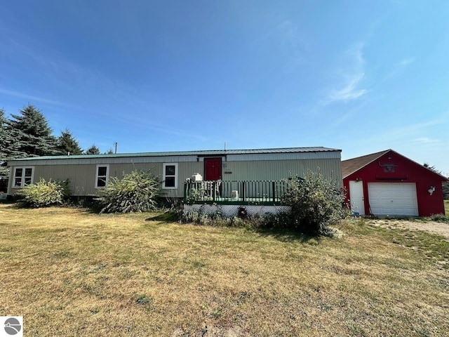 view of front of home with an outbuilding, a garage, and a front lawn