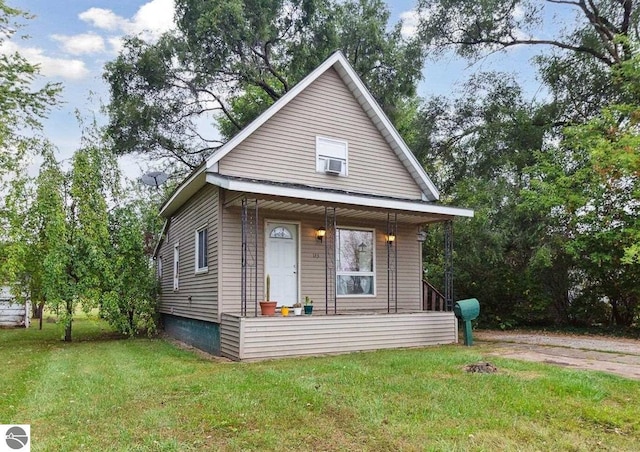 bungalow-style home with covered porch, cooling unit, and a front yard