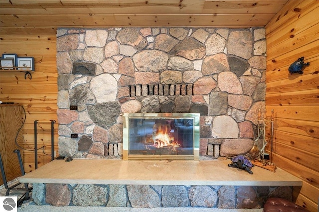 interior details with wood ceiling, a fireplace, and wood walls