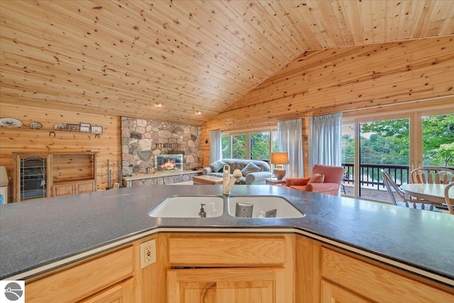 kitchen featuring light brown cabinets, wooden walls, sink, and wooden ceiling