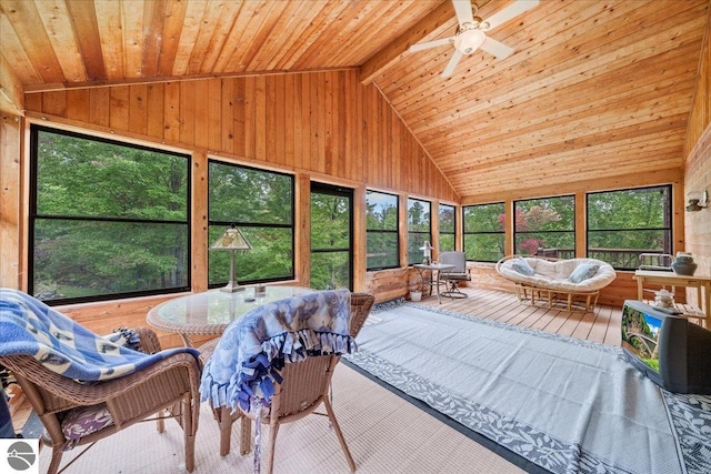 sunroom / solarium with ceiling fan, vaulted ceiling with beams, and wood ceiling