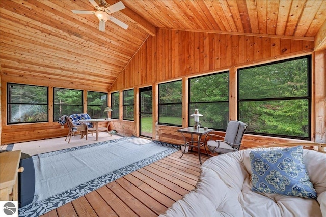 unfurnished sunroom featuring ceiling fan, vaulted ceiling with beams, and wood ceiling