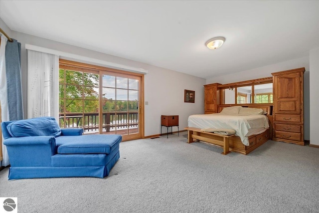 carpeted bedroom with a water view and access to outside