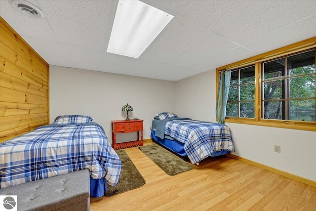 bedroom featuring hardwood / wood-style flooring and wooden walls