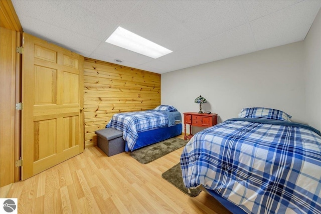 bedroom featuring wood walls and wood-type flooring