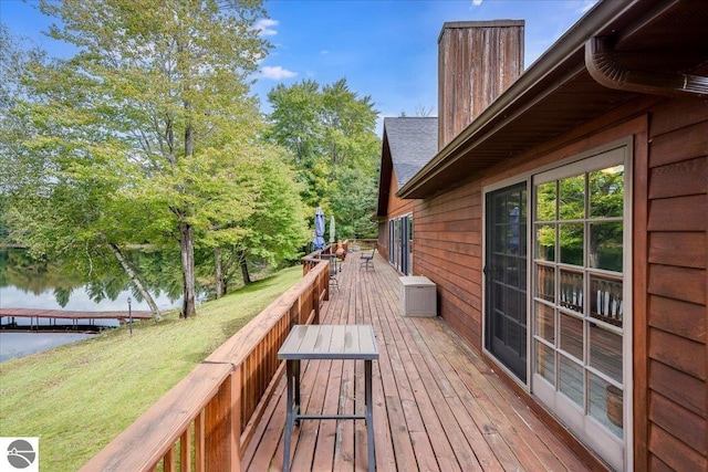 wooden deck featuring a water view and a yard