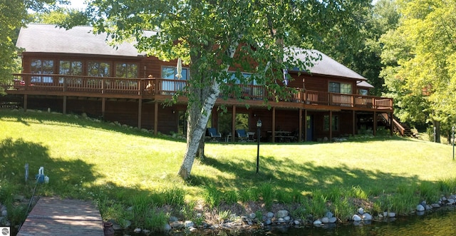 back of property featuring a lawn and a deck