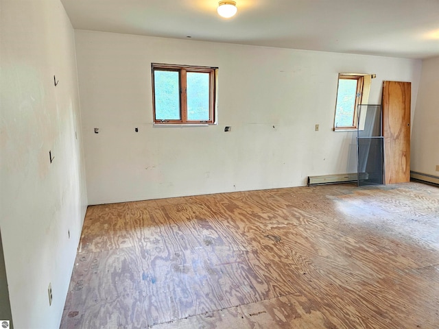 unfurnished room featuring a baseboard radiator and a wealth of natural light