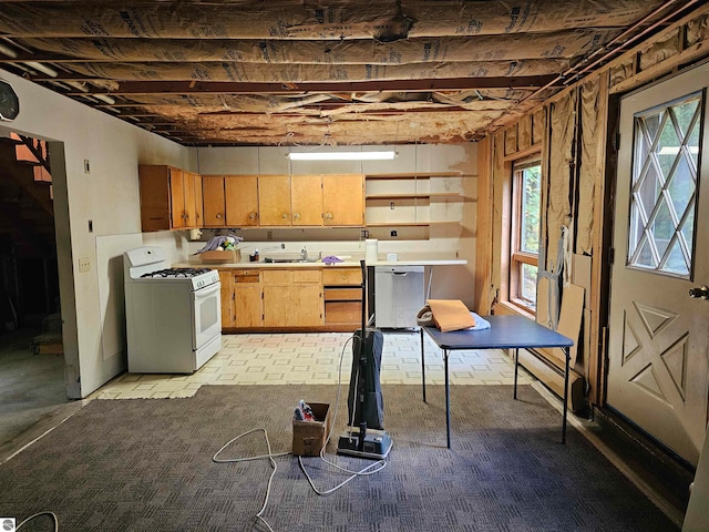 kitchen featuring a healthy amount of sunlight, stainless steel dishwasher, white range with gas stovetop, and sink