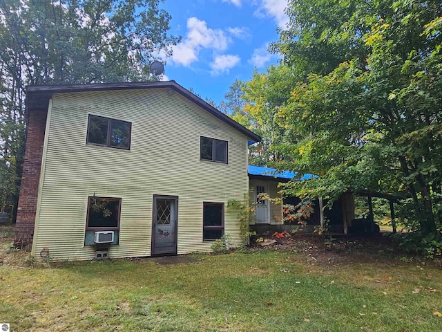 rear view of property featuring a lawn