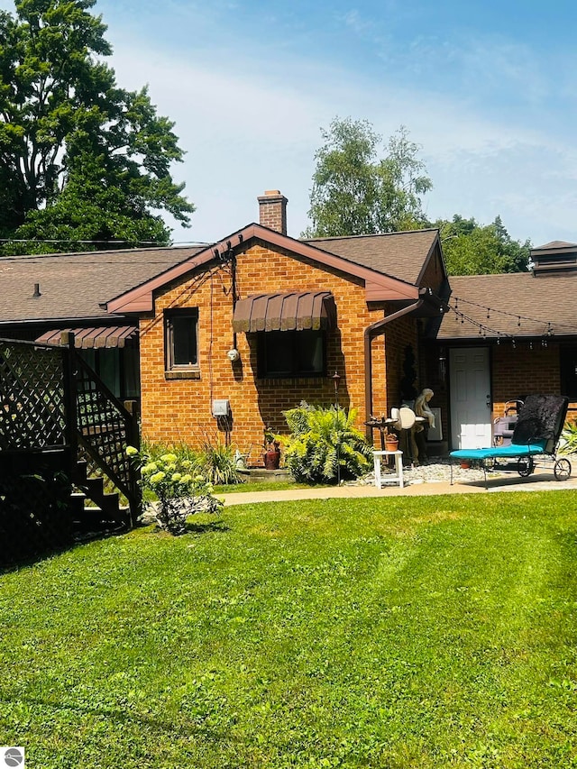 rear view of property with a yard