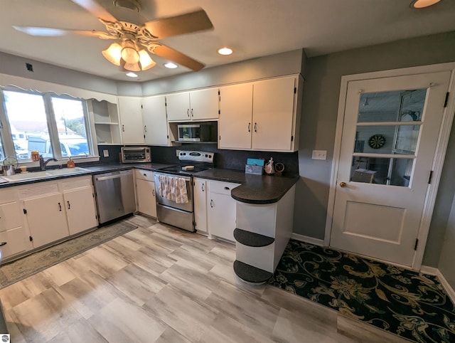 kitchen featuring sink, white cabinets, stainless steel appliances, backsplash, and ceiling fan