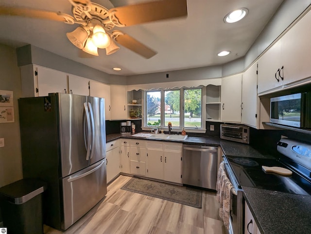 kitchen featuring light hardwood / wood-style floors, sink, white cabinets, appliances with stainless steel finishes, and ceiling fan