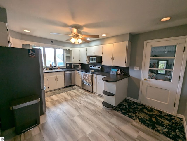 kitchen with ceiling fan, white cabinets, sink, stainless steel appliances, and light wood-type flooring