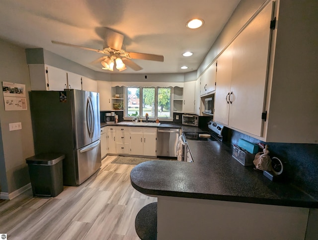 kitchen featuring light wood-type flooring, ceiling fan, stainless steel appliances, and white cabinets