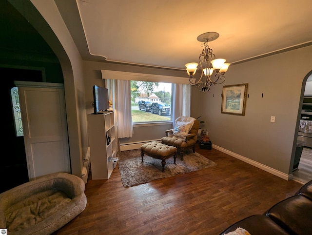 sitting room featuring a notable chandelier, baseboard heating, and dark hardwood / wood-style floors