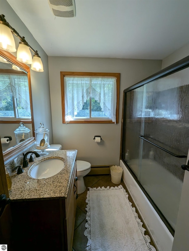 full bathroom featuring shower / bath combination with glass door, vanity, tile patterned flooring, a baseboard radiator, and toilet