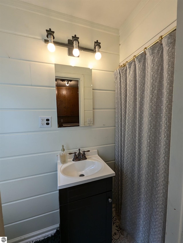 bathroom with crown molding, wood walls, and vanity