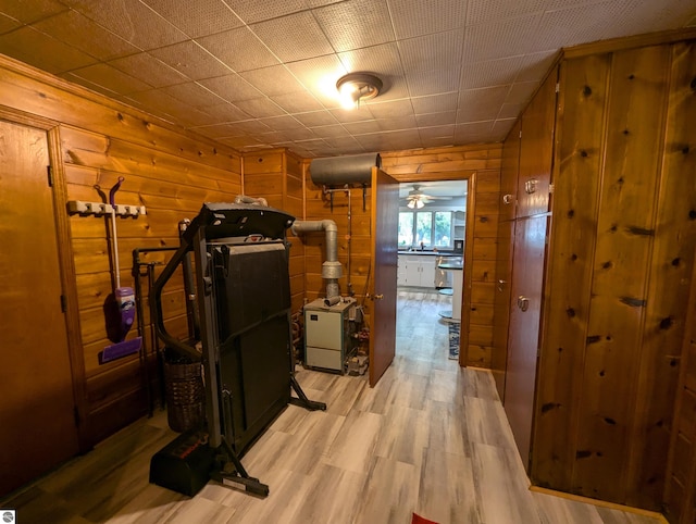 corridor featuring light wood-type flooring and wood walls