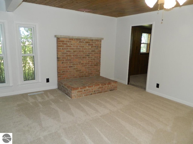 unfurnished living room with wooden ceiling, ceiling fan, and light colored carpet