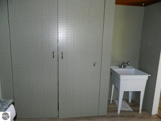 clothes washing area with wood-type flooring