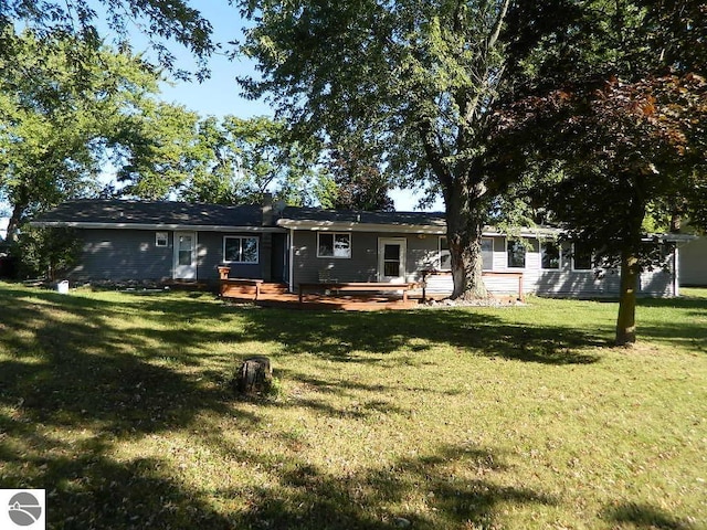 rear view of property featuring a deck and a yard