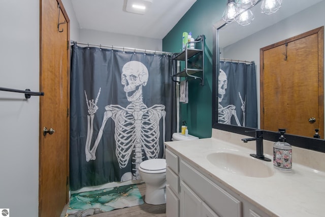 bathroom with walk in shower, hardwood / wood-style flooring, vanity, and toilet