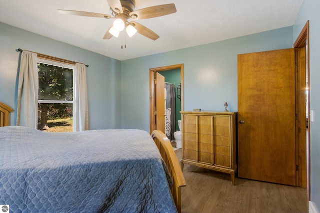 bedroom with ensuite bath, ceiling fan, a walk in closet, and hardwood / wood-style floors