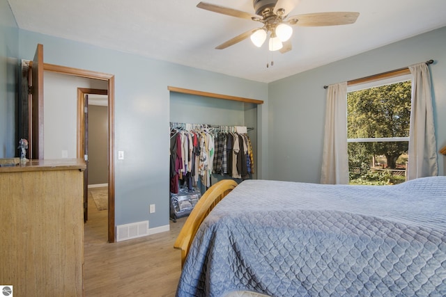 bedroom with a closet, light wood-type flooring, and ceiling fan