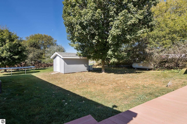 view of yard with a trampoline and a shed