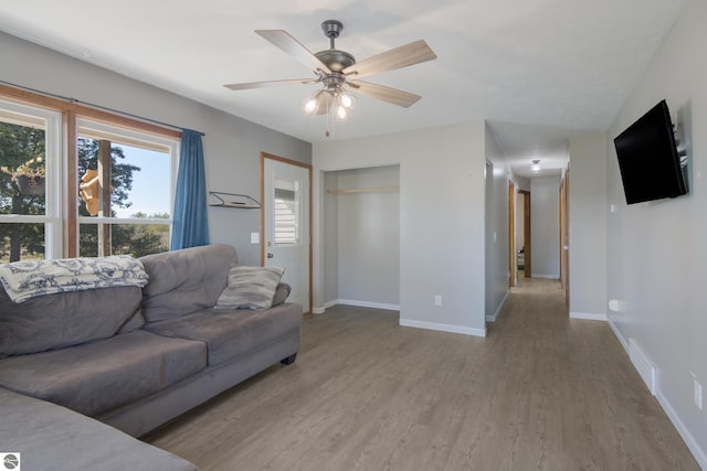 living room with ceiling fan and light wood-type flooring