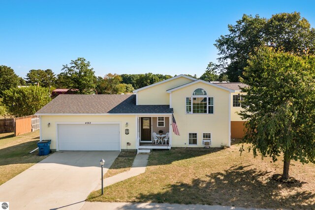 split level home with a garage and a front lawn