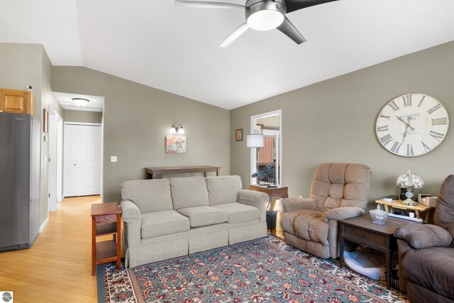 living room with wood-type flooring, vaulted ceiling, and ceiling fan