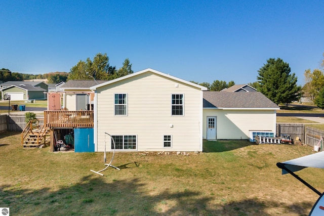 rear view of property featuring a yard and a wooden deck