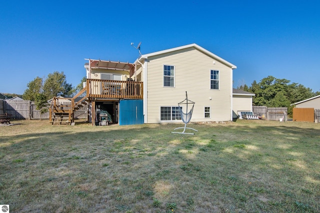 rear view of property featuring a wooden deck and a yard