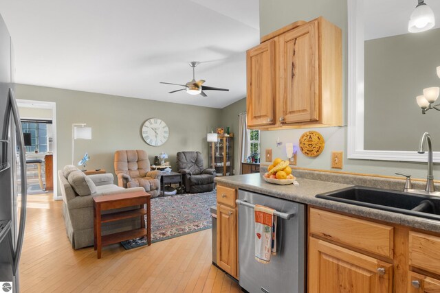 kitchen with vaulted ceiling, sink, stainless steel dishwasher, ceiling fan, and light hardwood / wood-style floors