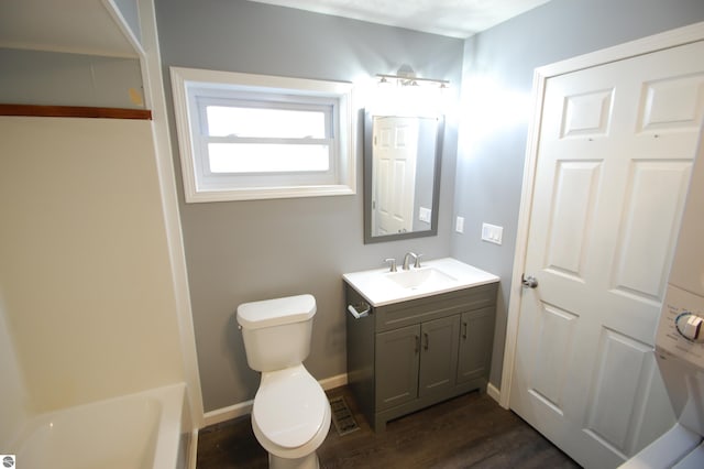 full bathroom featuring wood-type flooring, vanity, bathing tub / shower combination, and toilet