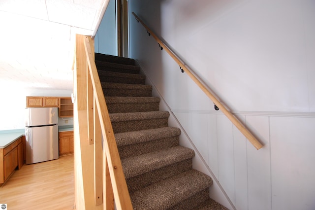 stairway with hardwood / wood-style flooring and vaulted ceiling