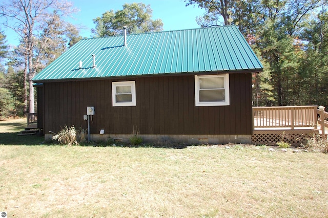 view of property exterior with a deck and a lawn