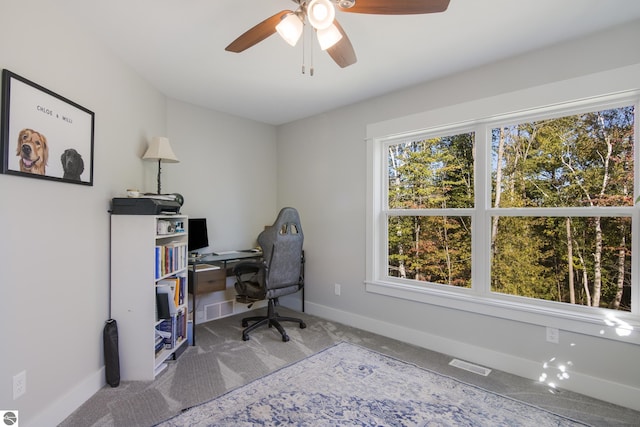 carpeted home office featuring ceiling fan