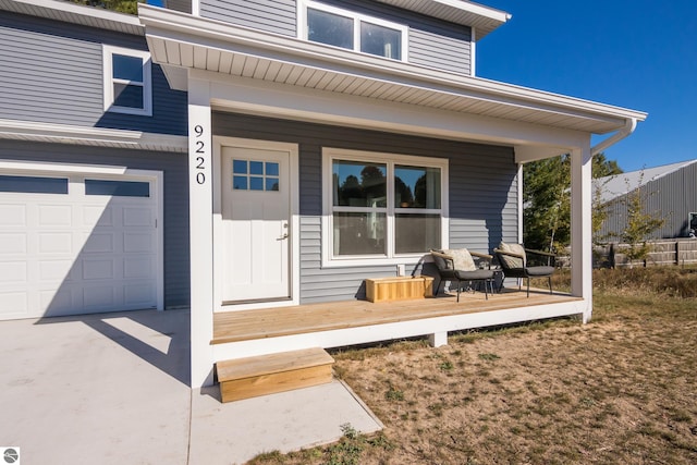 doorway to property with a garage and covered porch