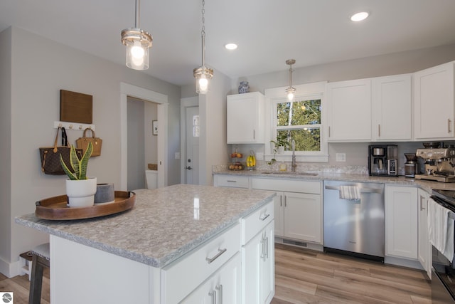 kitchen featuring hanging light fixtures, stainless steel dishwasher, sink, and white cabinets