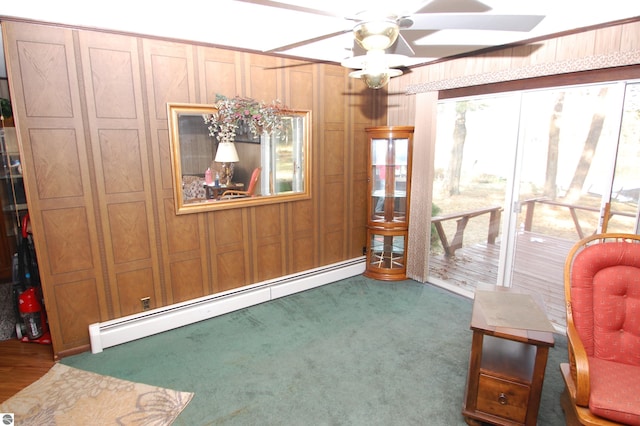 2169 Brady Dr, West Branch, MI 48661 - carpeted dining area with a baseboard heating unit, ceiling fan, and wood walls